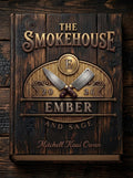 The Smokehouse cookbook cover with dark wood-grain background, gold Ember and Sage lettering, crossed cleavers, and the author name Mitchell Kaui Owan.