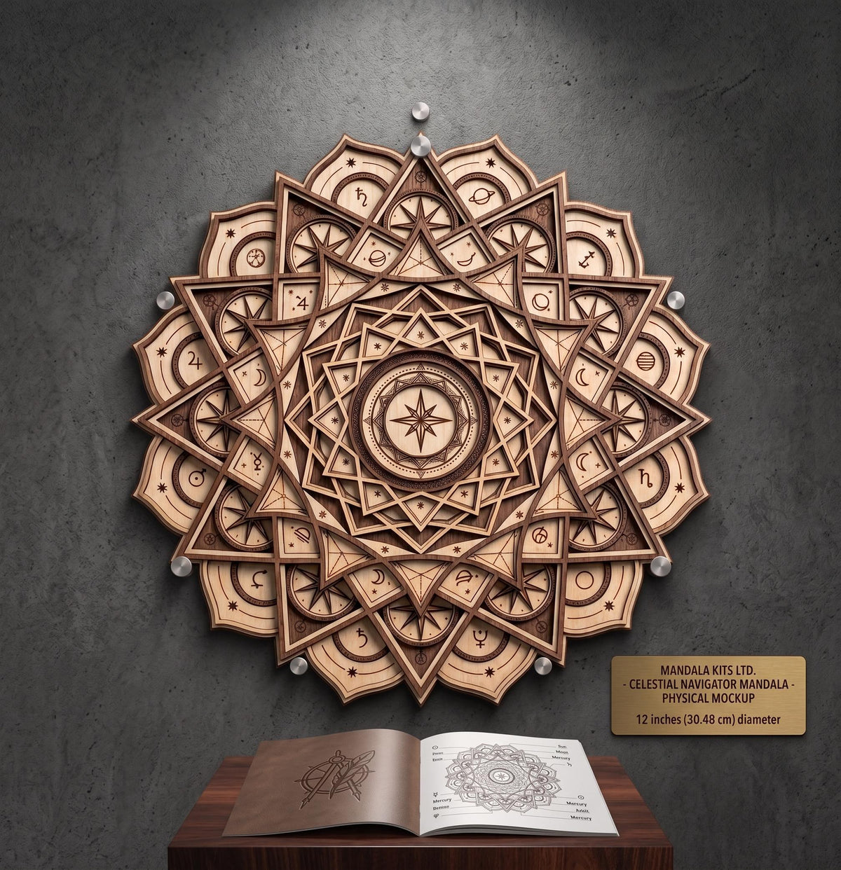 The 3D layered wooden celestial mandala mounted on a dark gray wall above a pedestal displaying an open technical drawing book and a small descriptive plaque.