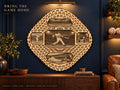 A 3D layered laser-cut wooden baseball mandala wall art piece hanging on a dark blue wall above a wooden console table.