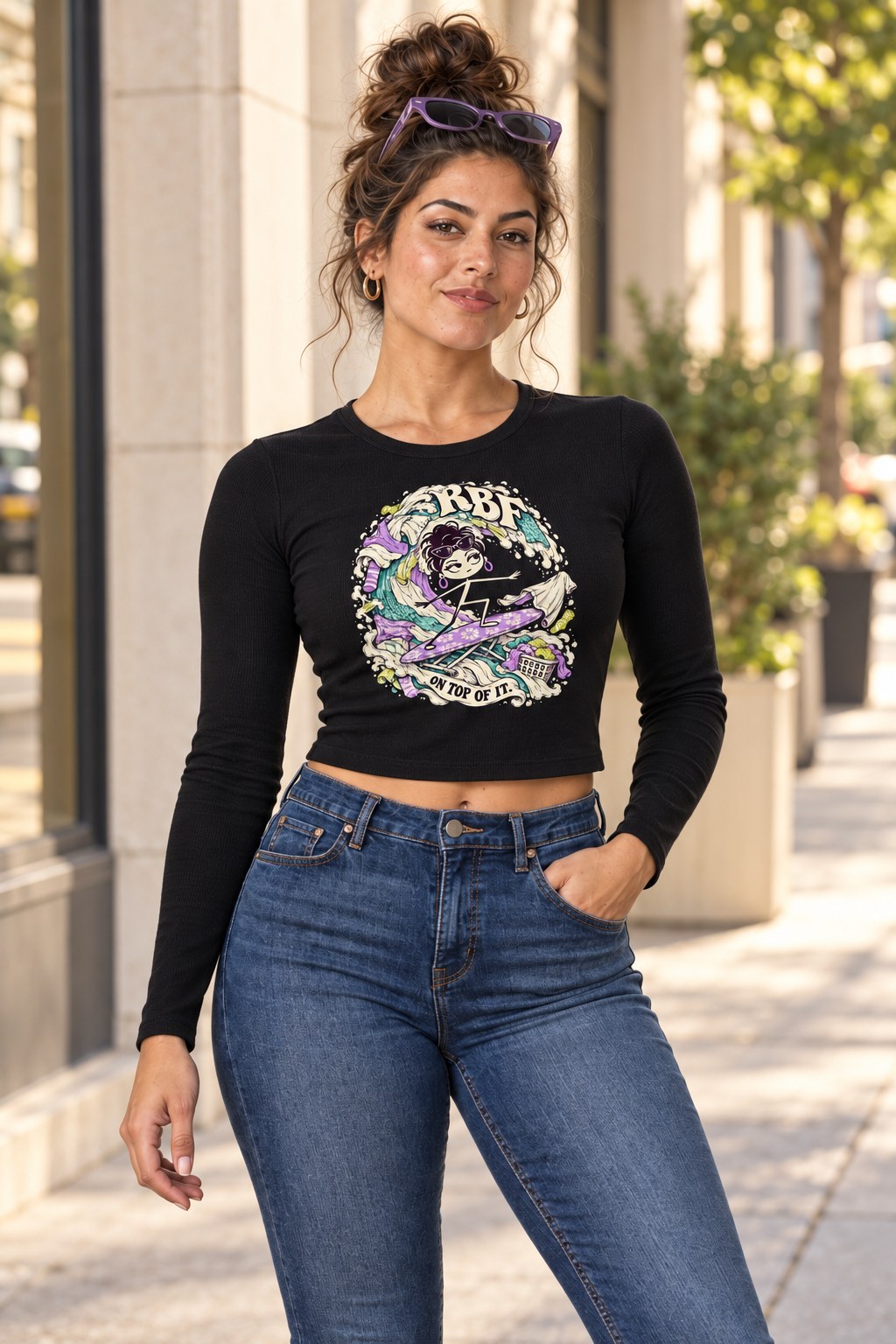 Lifestyle mockup: Laundry Tsunami long-sleeve baby tee in Black. Street-style portrait with the front design visible.