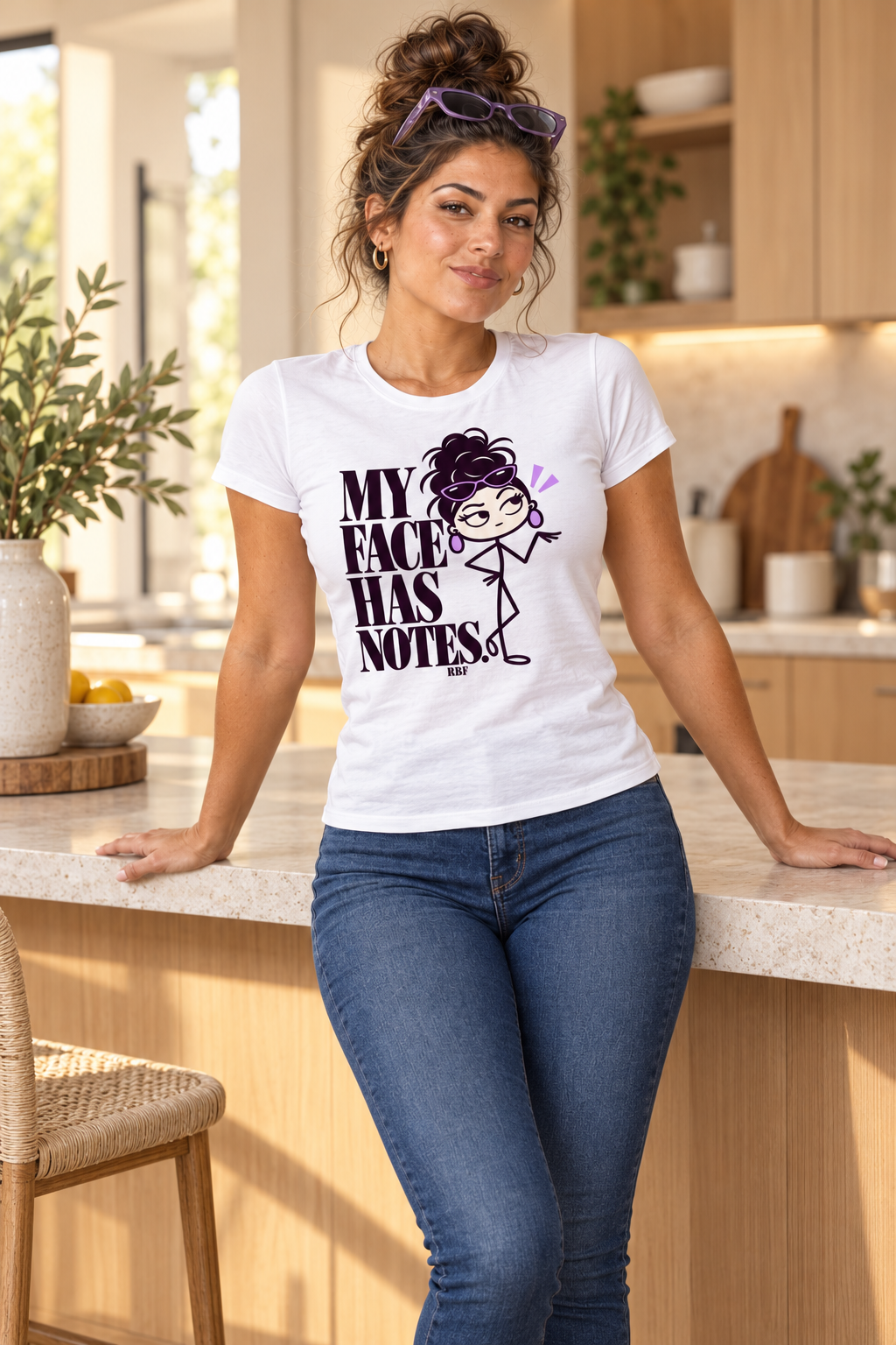 Lifestyle mockup: My Face Has Notes graphic tee in White. Leaning against a kitchen counter with the front design visible.